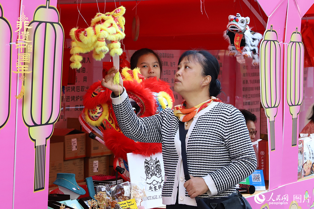 2025-08-04，2025深圳节日大道元宵奇妙会暨深潮文化周活动现场，市民正在选购广东醒狮。人民网 江佳玲摄